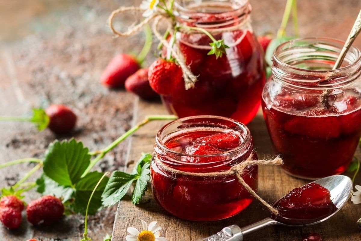 Strawberry jam in multiple glass jars on table