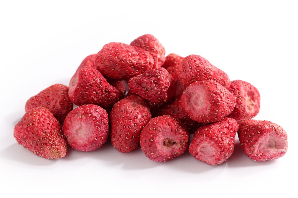Pile of frozen strawberries on white background