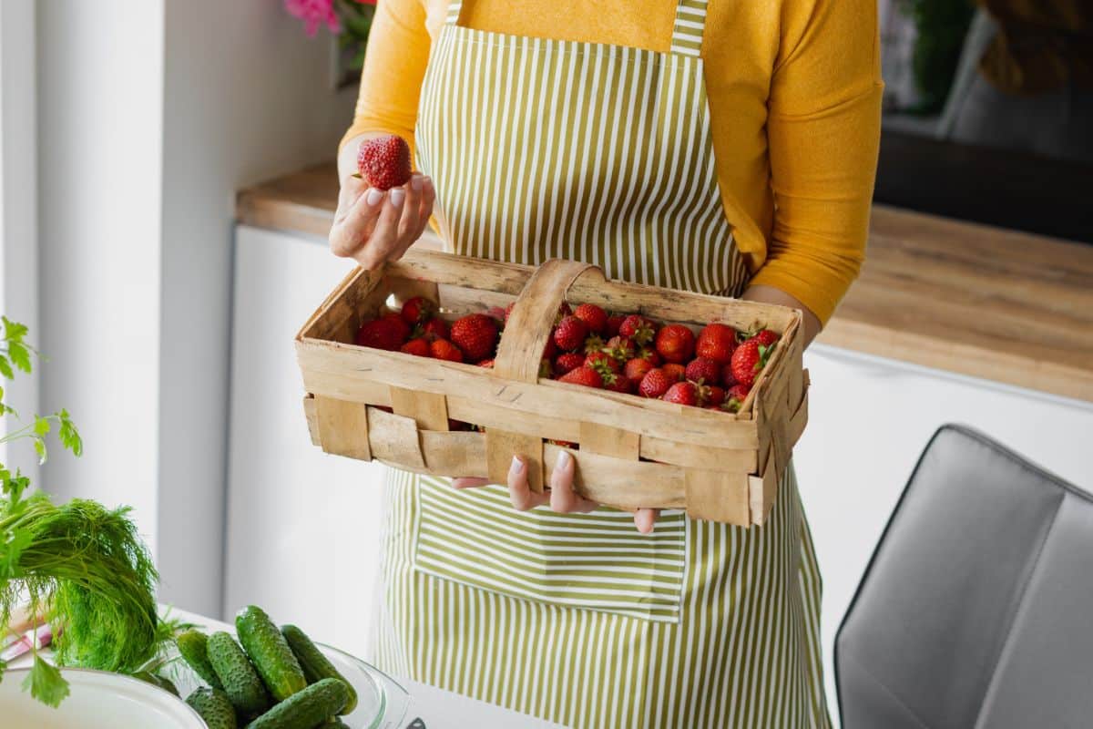 A woman with a basket of fresh strawberries