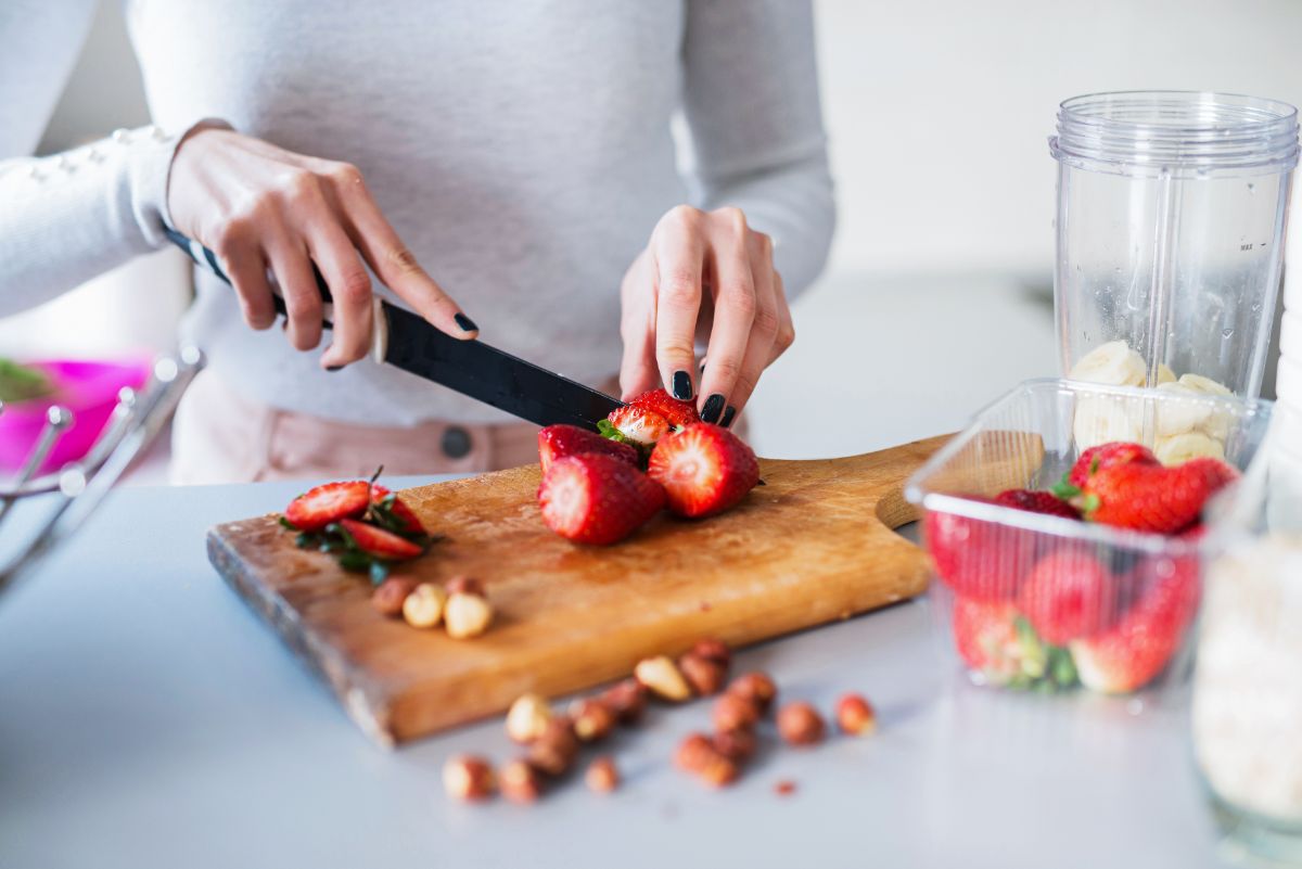 A woman cutting tops off strawberries