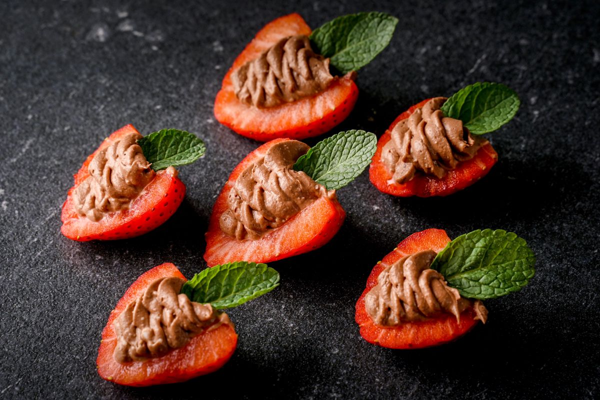 Deviled strawberries on a black table.