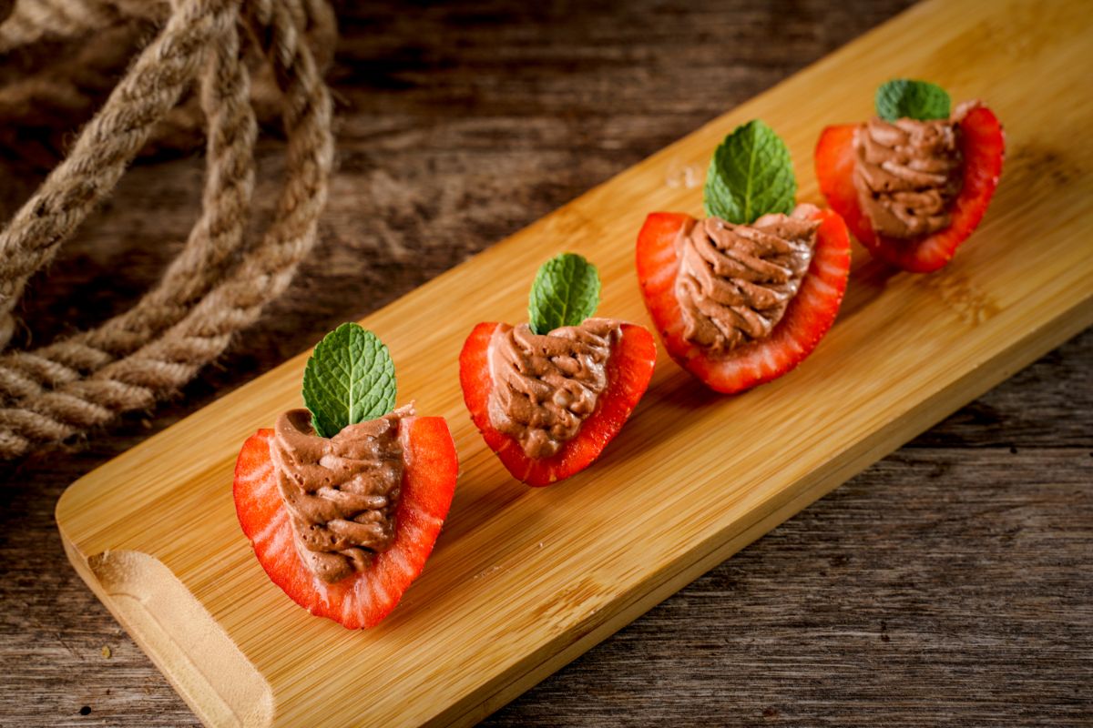 Deviled strawberries on a wooden board.
