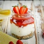 A noe bake keto strawberry cheesecake jar on a wooden table.