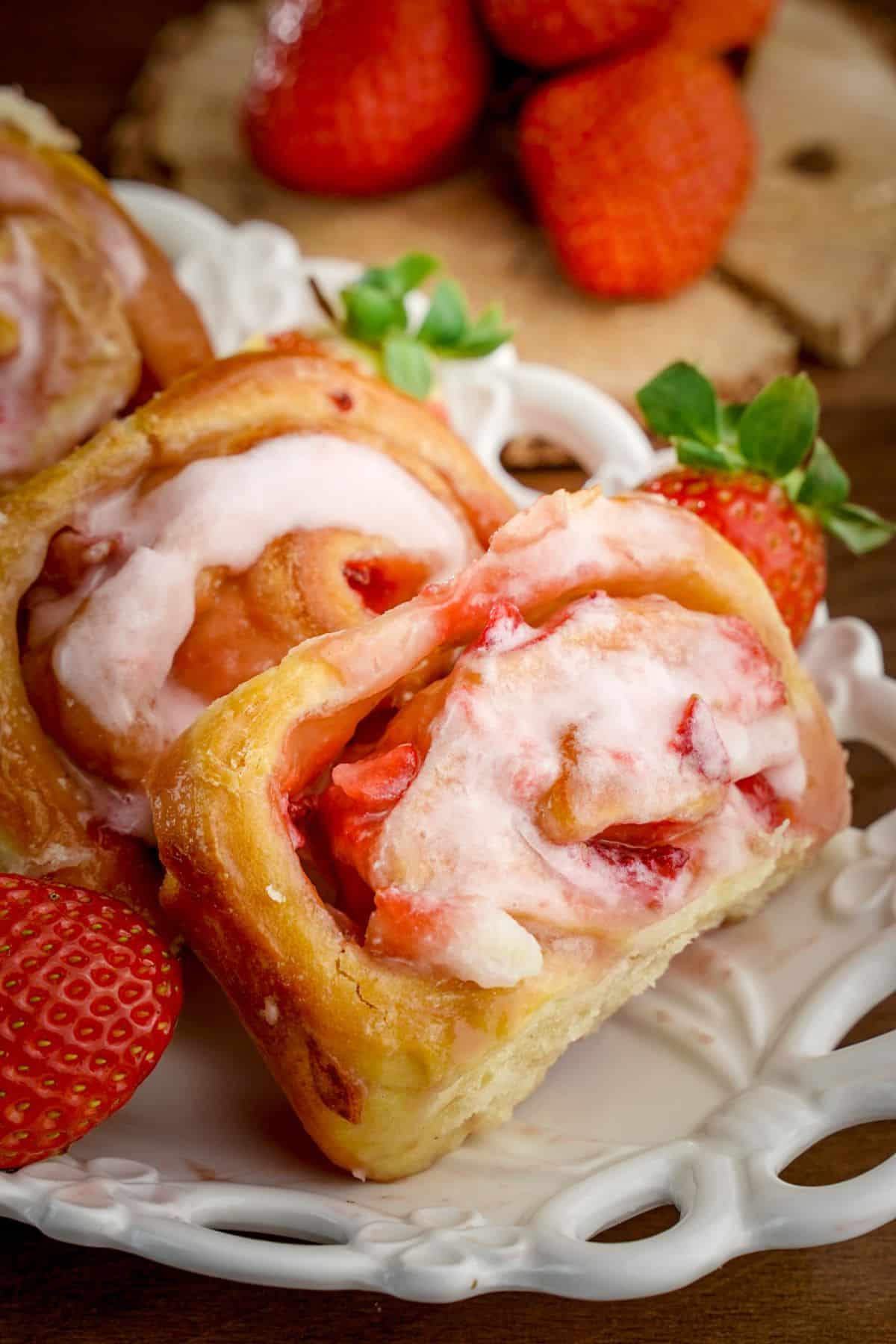 A close-up of Strawberries and Cream Sweet Rolls on a white tray.