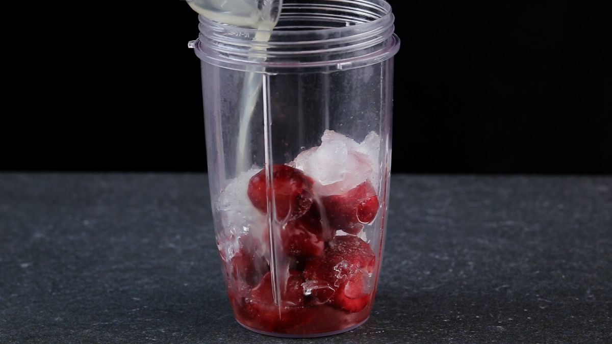 Ice cubes and strawberries in a blender.