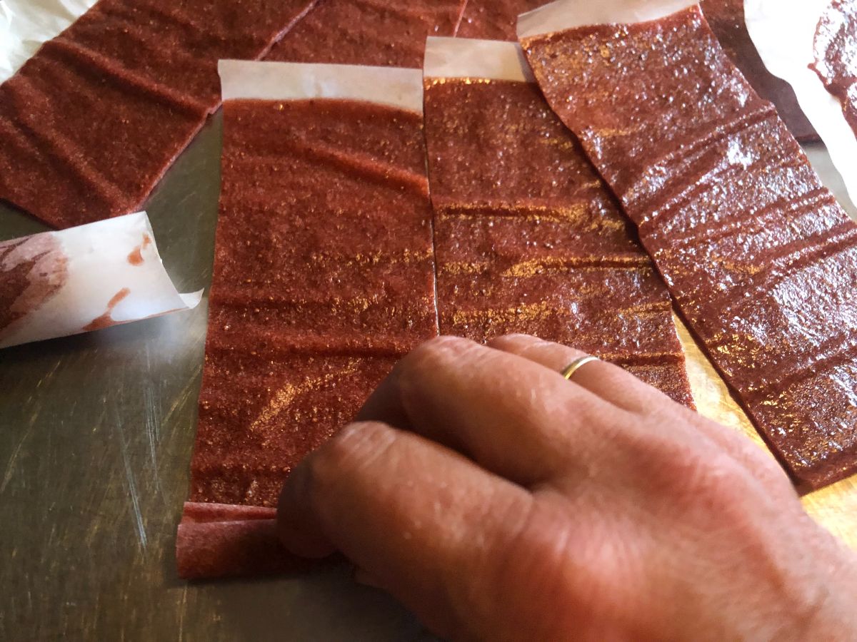 Rolling up the strawberry fruit leathers.