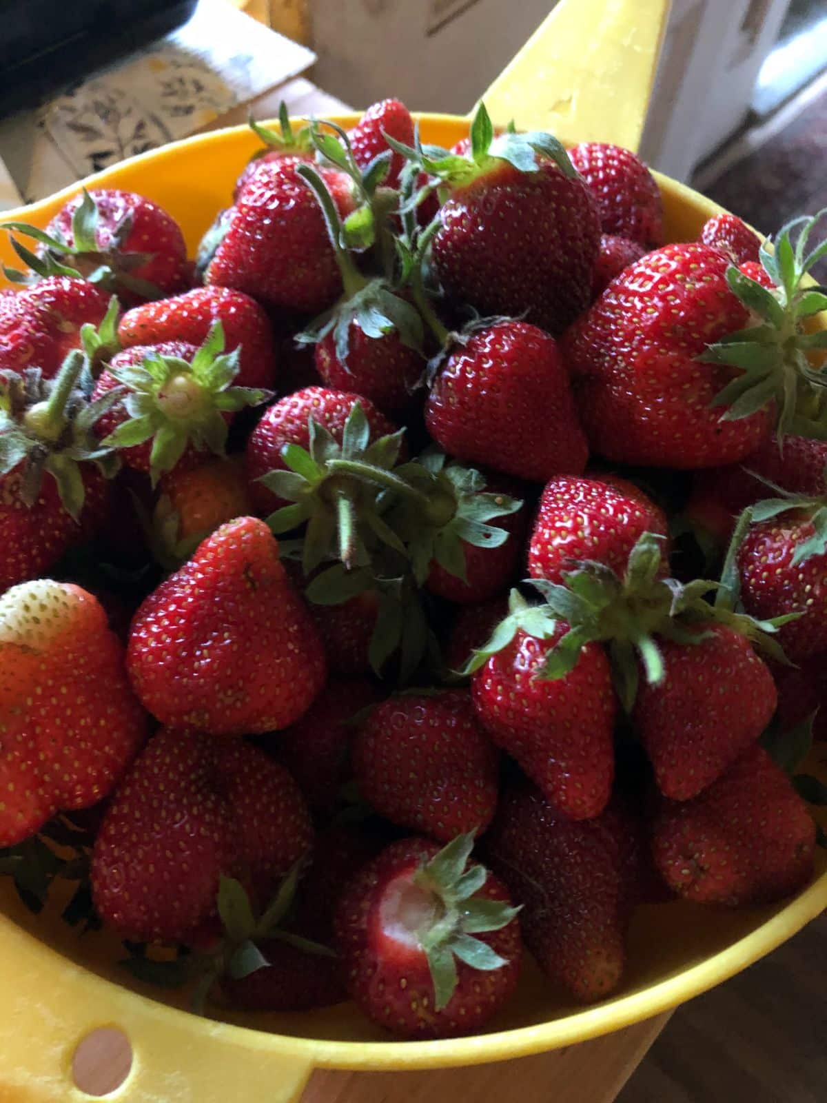 Strawberries in a basket at varying levels of ripeness