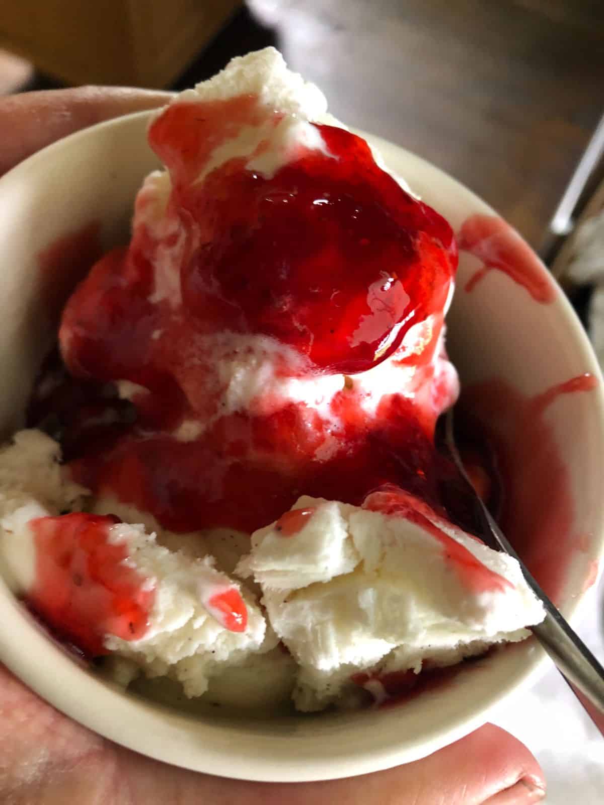 Homemade strawberry syrup over vanilla ice cream