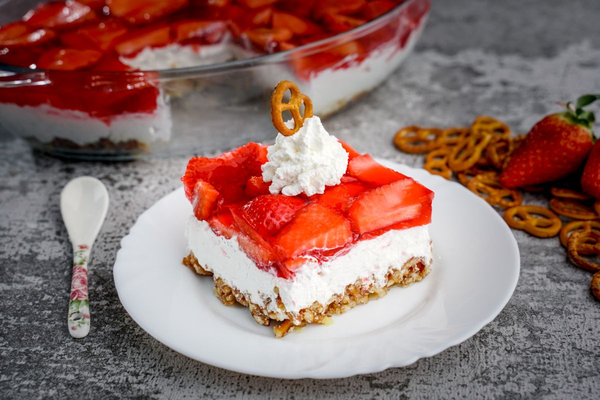 Strawberry pretzel salad piece on a white plate.