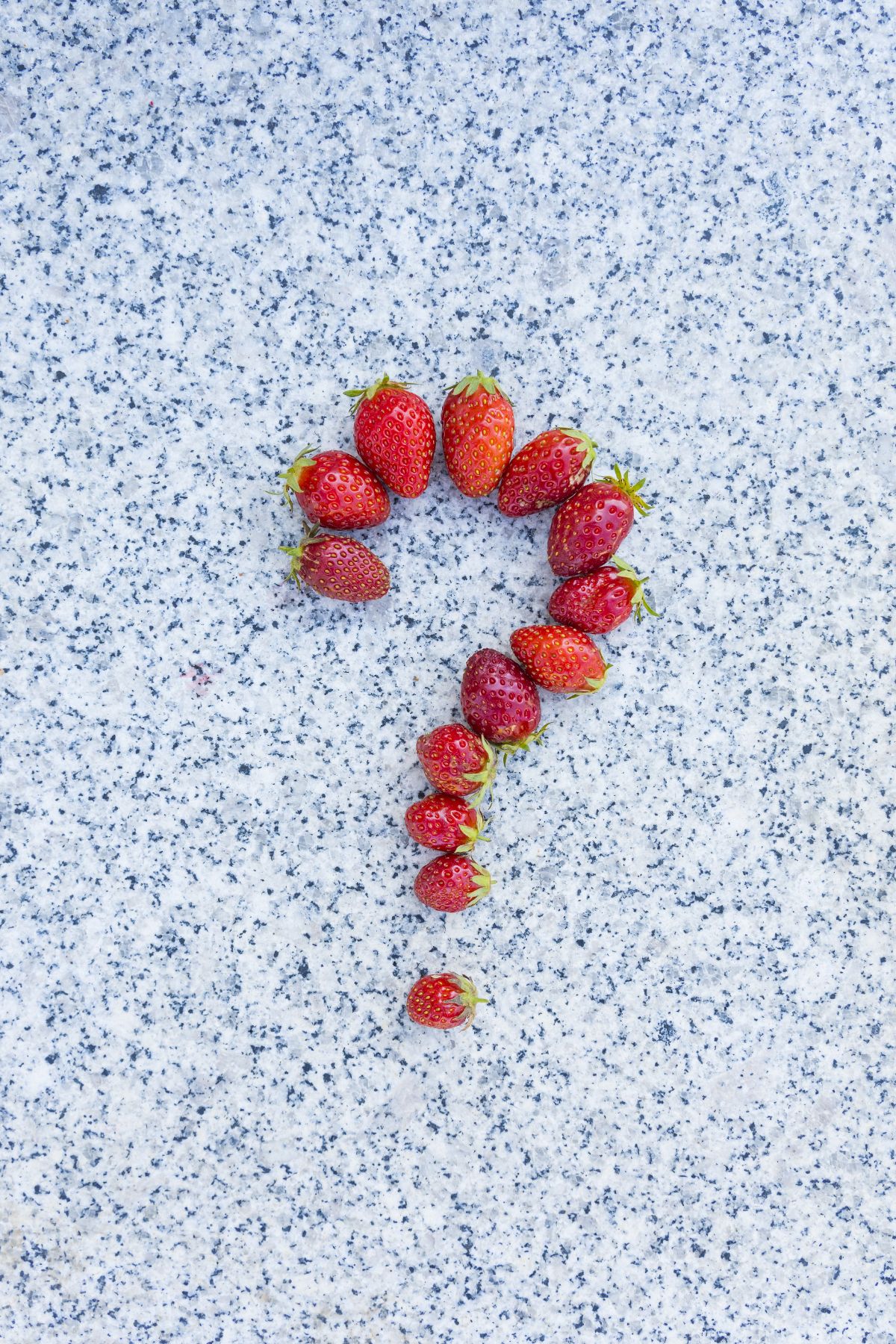 Strawberries on a counter in a question mark shape