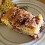 A piece of delicious Strawberry-Rhubarb Coffee Cake on a white plate.