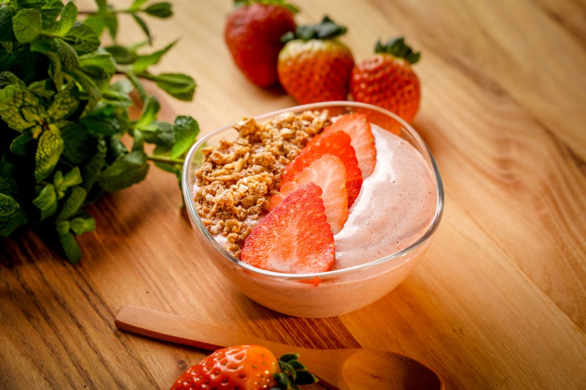 Strawberry vanilla smoothie bowl with sliced strawberries and pecans.