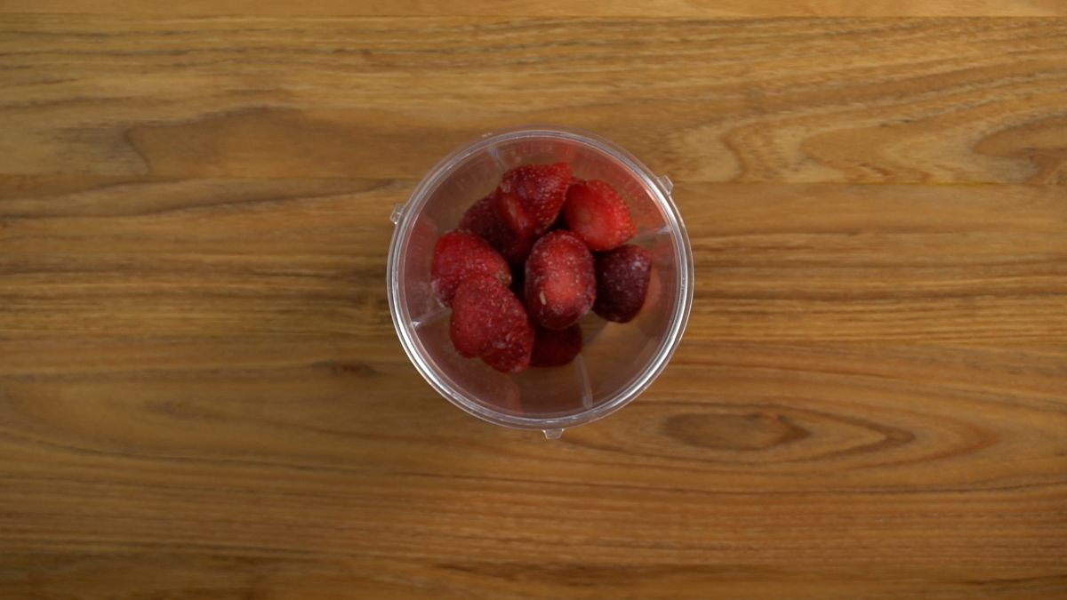 Blender full of frozen strawberries.