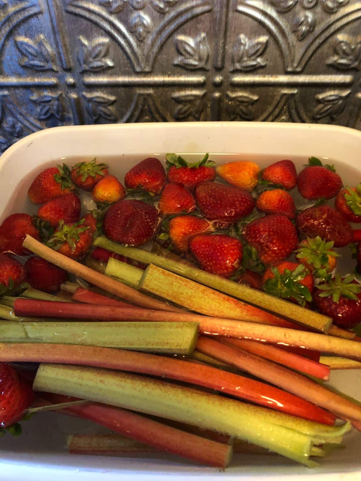 Strawberries and rhubarb in a basin of water